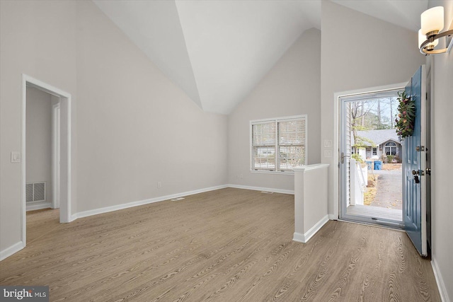 entryway with high vaulted ceiling, baseboards, visible vents, and wood finished floors