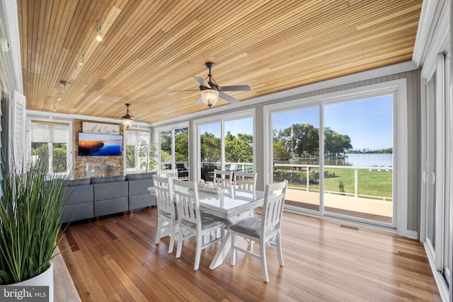 sunroom / solarium featuring plenty of natural light, ceiling fan, and wood ceiling