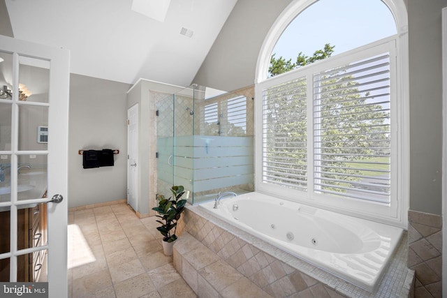 bathroom with separate shower and tub, vaulted ceiling, and a healthy amount of sunlight