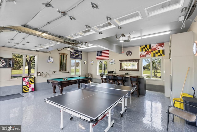 game room with bar, a healthy amount of sunlight, and pool table