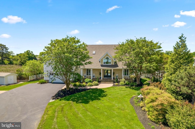 cape cod house with a front yard, a garage, and covered porch