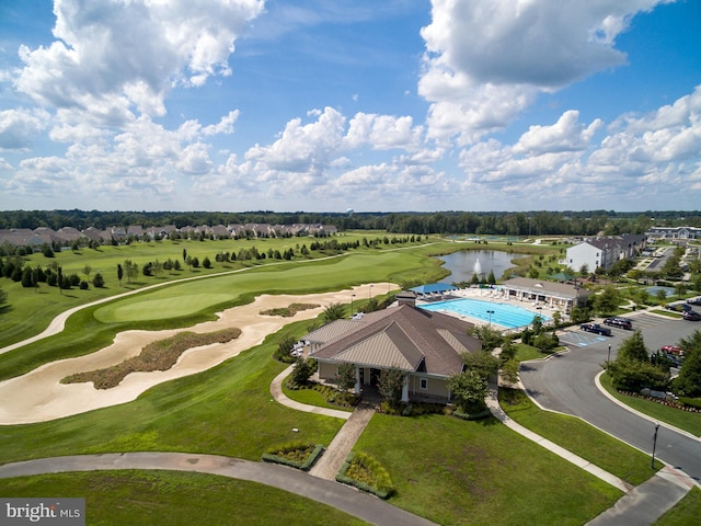 drone / aerial view with golf course view and a water view