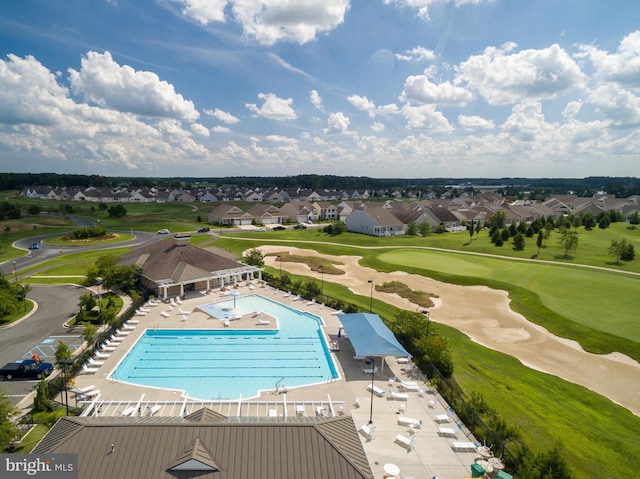 pool with a residential view, view of golf course, a patio, and fence