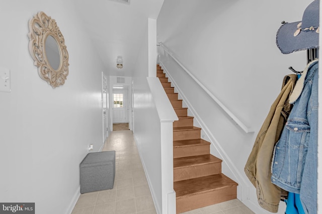 staircase with tile patterned flooring, visible vents, and baseboards