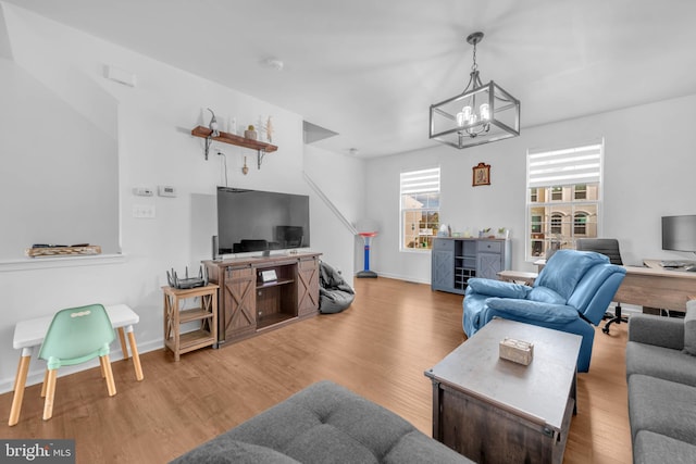 living room featuring a chandelier, wood finished floors, and baseboards