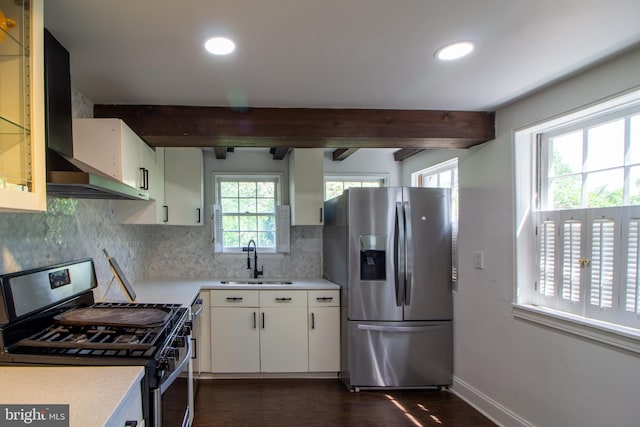 kitchen with white cabinets, sink, wall chimney exhaust hood, appliances with stainless steel finishes, and beam ceiling