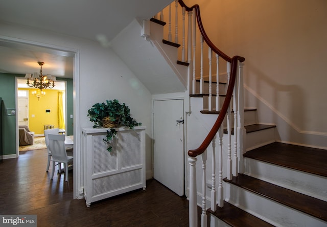 stairway with hardwood / wood-style flooring and a notable chandelier