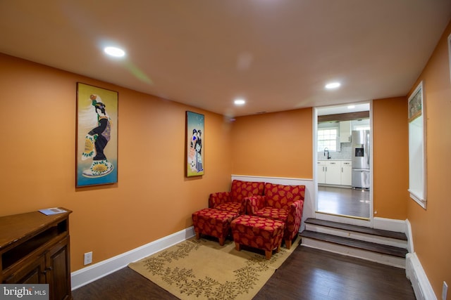 sitting room with wood-type flooring, sink, and a baseboard radiator