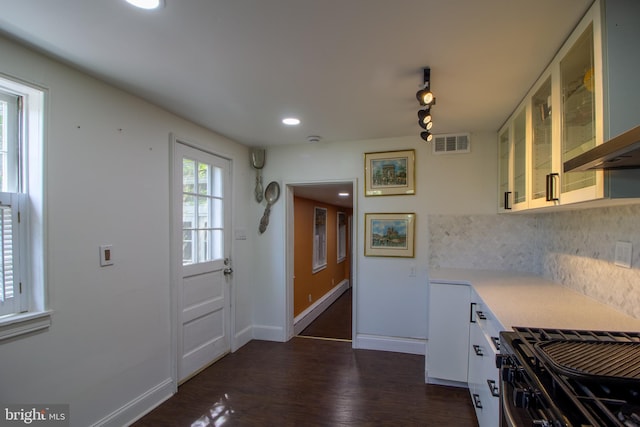 kitchen with decorative backsplash, rail lighting, ventilation hood, white cabinets, and stainless steel range with gas stovetop