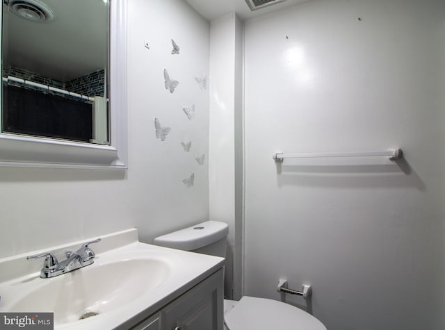 bathroom featuring a shower with curtain, vanity, and toilet