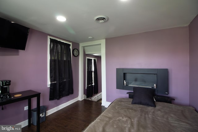 bedroom with a baseboard radiator and hardwood / wood-style flooring