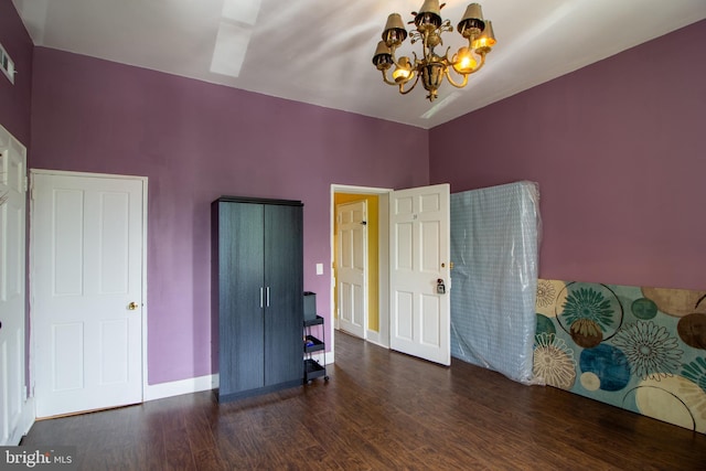 bedroom featuring a chandelier and dark hardwood / wood-style flooring