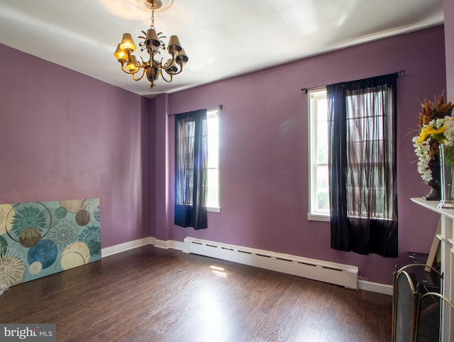 unfurnished room with baseboard heating, a healthy amount of sunlight, dark hardwood / wood-style floors, and a notable chandelier