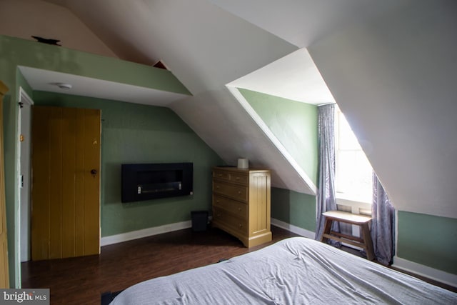 bedroom featuring dark wood-type flooring and vaulted ceiling