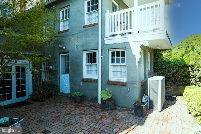 back of house with french doors, a patio, and a balcony