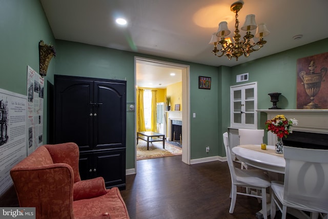 dining room with dark hardwood / wood-style flooring and a chandelier