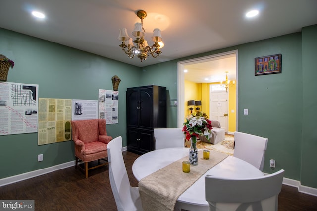 dining room with dark hardwood / wood-style floors and an inviting chandelier