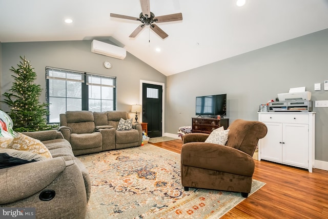 living room with ceiling fan, vaulted ceiling, an AC wall unit, and light hardwood / wood-style flooring