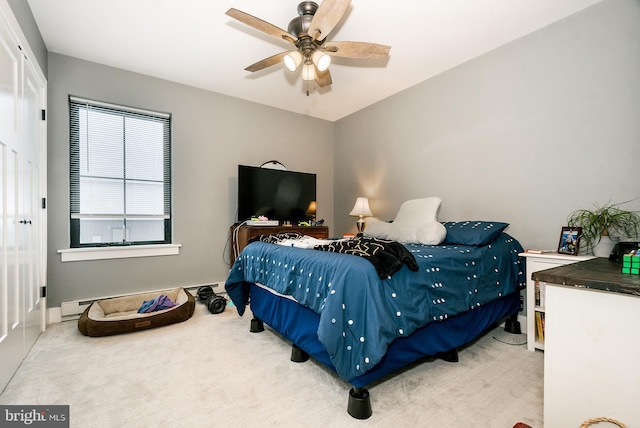 carpeted bedroom with ceiling fan and a baseboard heating unit