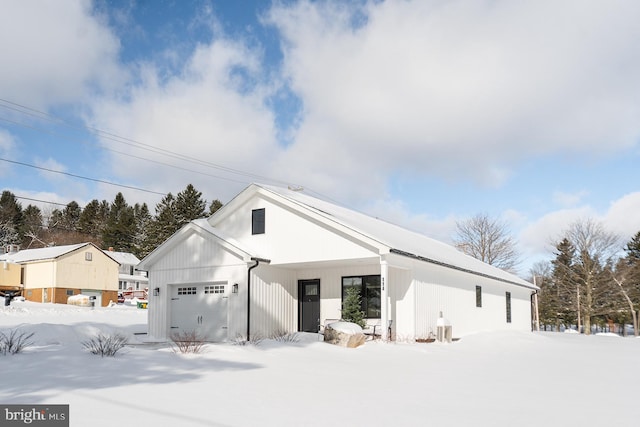 view of front of home featuring central air condition unit and a garage