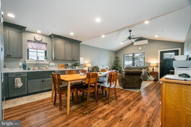 dining room featuring ceiling fan, sink, dark hardwood / wood-style flooring, and lofted ceiling