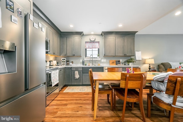 kitchen featuring gray cabinets, sink, appliances with stainless steel finishes, and light hardwood / wood-style flooring