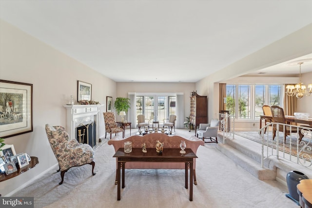 carpeted living room featuring a premium fireplace and a chandelier