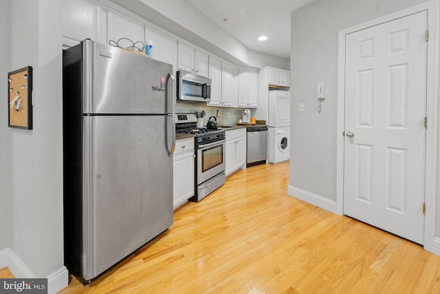 kitchen featuring stacked washer / drying machine, white cabinetry, appliances with stainless steel finishes, and tasteful backsplash