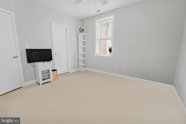 unfurnished bedroom featuring light carpet and ceiling fan