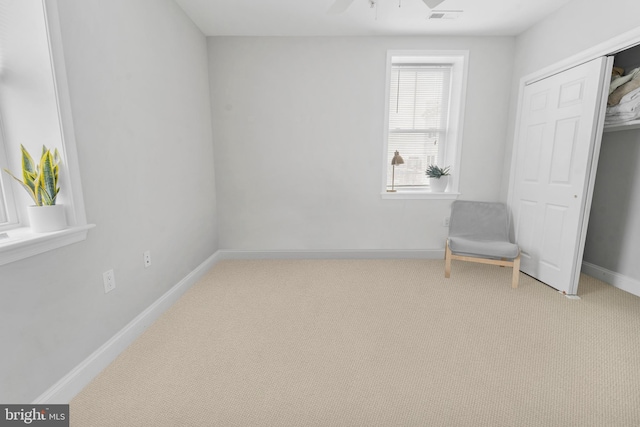 living area featuring carpet and ceiling fan