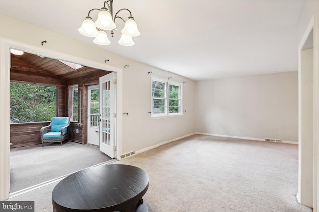 entryway featuring carpet flooring, a wealth of natural light, and an inviting chandelier