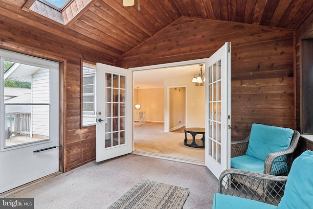 unfurnished sunroom with french doors, an inviting chandelier, wood ceiling, and vaulted ceiling with skylight