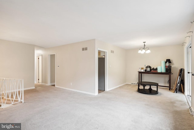 carpeted spare room with a notable chandelier