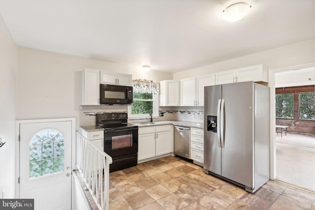 kitchen with black appliances, white cabinets, sink, and a wealth of natural light