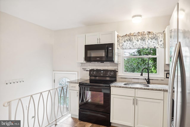 kitchen featuring light stone countertops, white cabinetry, sink, light tile patterned floors, and black appliances