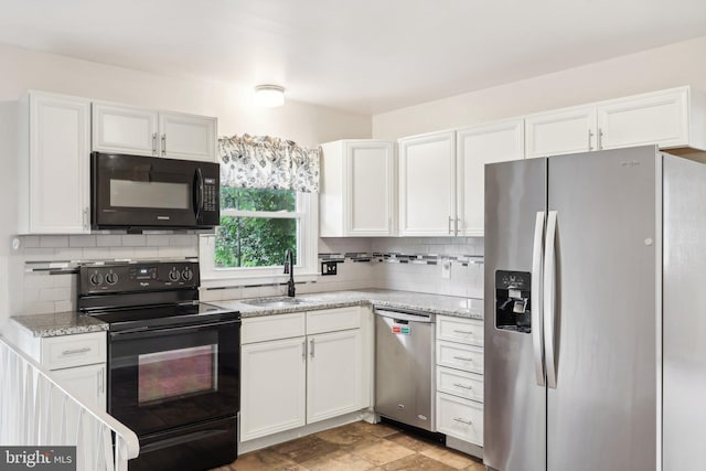 kitchen featuring backsplash, light stone counters, sink, black appliances, and white cabinetry