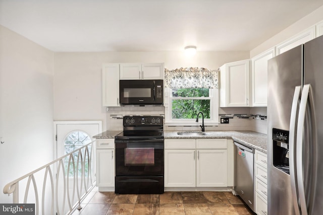 kitchen with black appliances, white cabinets, and sink