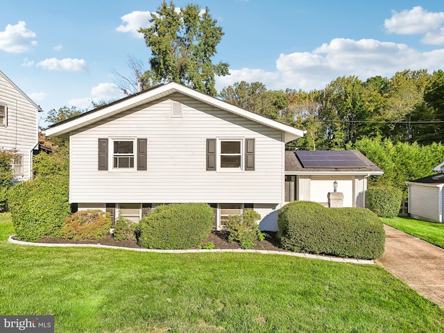 view of front of house featuring solar panels and a front lawn