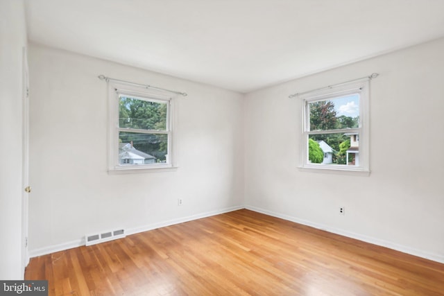 spare room featuring hardwood / wood-style floors and a healthy amount of sunlight