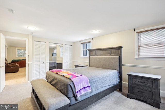 carpeted bedroom featuring multiple closets