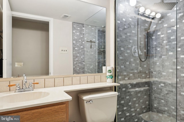 bathroom with vanity, a tile shower, backsplash, and toilet