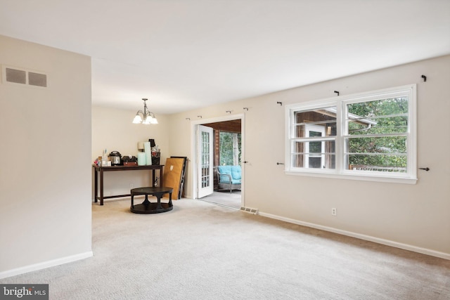 interior space featuring light carpet and a chandelier