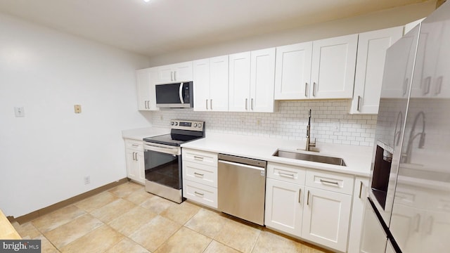 kitchen featuring appliances with stainless steel finishes, backsplash, white cabinetry, and sink