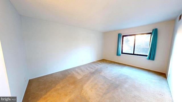 unfurnished room featuring light colored carpet