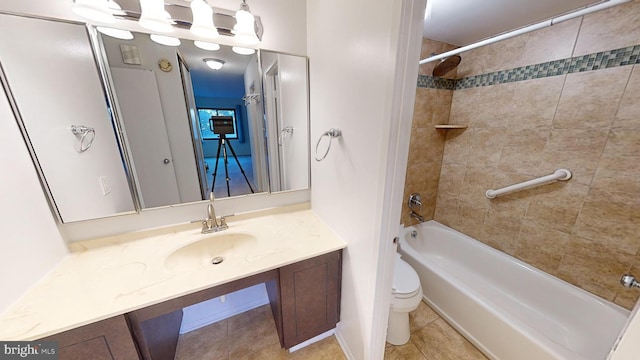 full bathroom featuring tile patterned floors, tiled shower / bath combo, toilet, and vanity