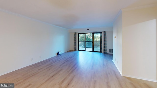 empty room featuring light hardwood / wood-style flooring and crown molding