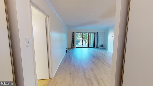 hallway featuring crown molding and light hardwood / wood-style floors