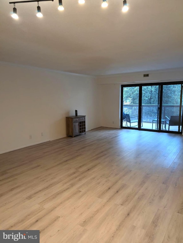 unfurnished living room featuring rail lighting, light hardwood / wood-style flooring, and ornamental molding