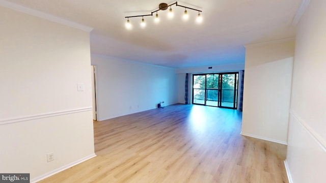 unfurnished room featuring light wood-type flooring, ornamental molding, and track lighting