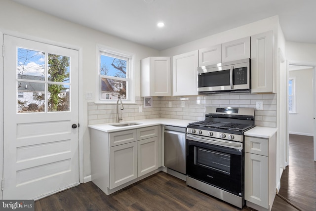 kitchen with white cabinets, backsplash, stainless steel appliances, and sink